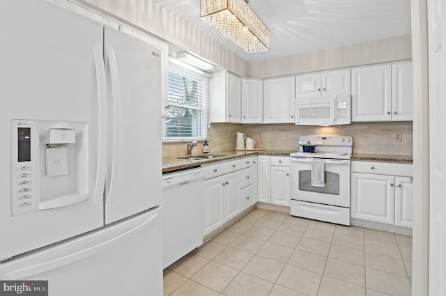 kitchen with sink, white cabinets, white appliances, and dark stone counters