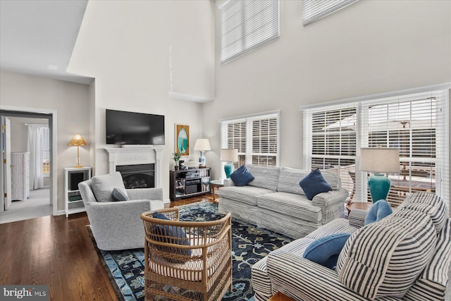 living room with dark hardwood / wood-style flooring and a towering ceiling