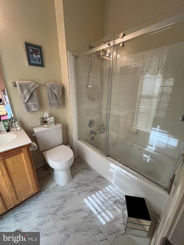 full bathroom featuring enclosed tub / shower combo, vanity, and toilet