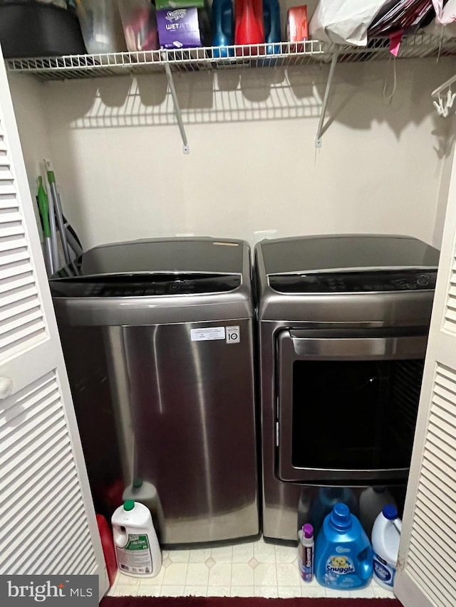 clothes washing area with washer and clothes dryer