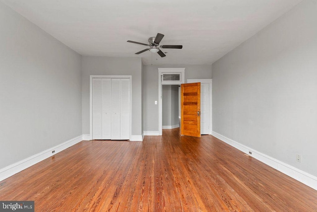 unfurnished bedroom with hardwood / wood-style flooring, ceiling fan, and a closet