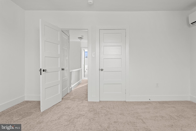 spare room featuring light colored carpet and an AC wall unit