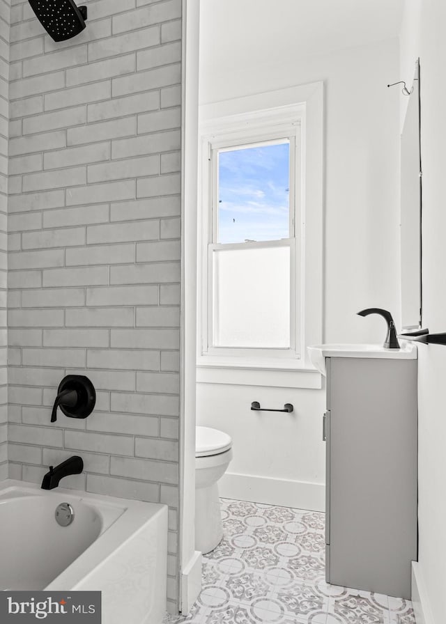 full bathroom with tiled shower / bath, vanity, tile patterned floors, and toilet