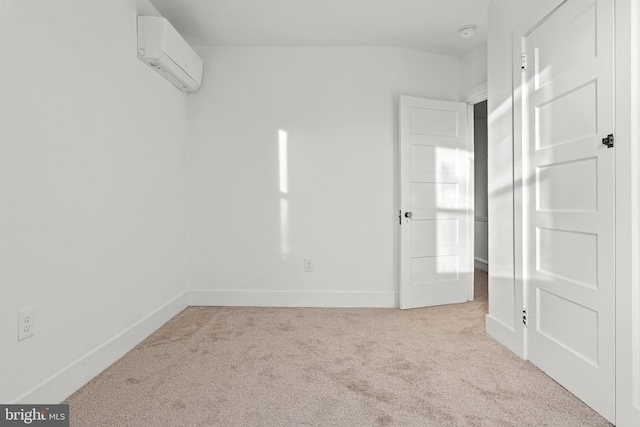 spare room featuring light carpet and an AC wall unit