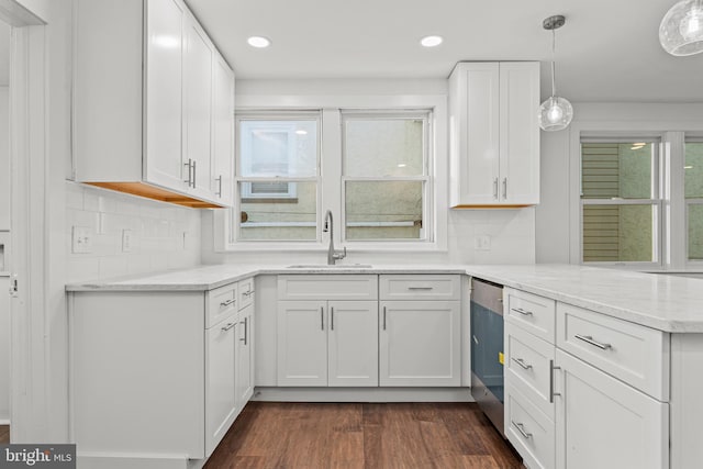 kitchen featuring sink, white cabinetry, hanging light fixtures, dark hardwood / wood-style floors, and light stone countertops