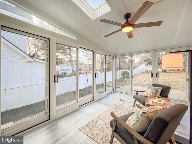 sunroom / solarium featuring lofted ceiling with skylight and ceiling fan