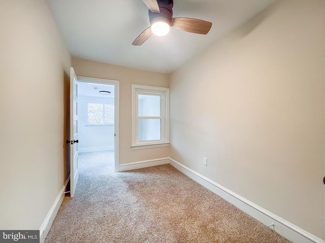 carpeted spare room with ceiling fan