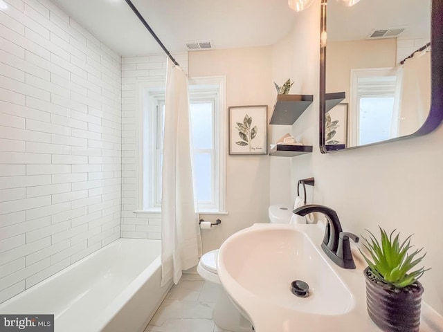 full bathroom featuring sink, shower / tub combo, and toilet