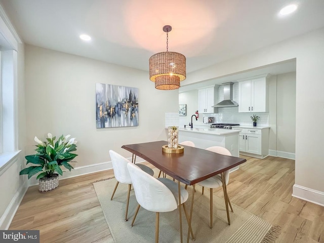 dining space with a chandelier and light hardwood / wood-style flooring