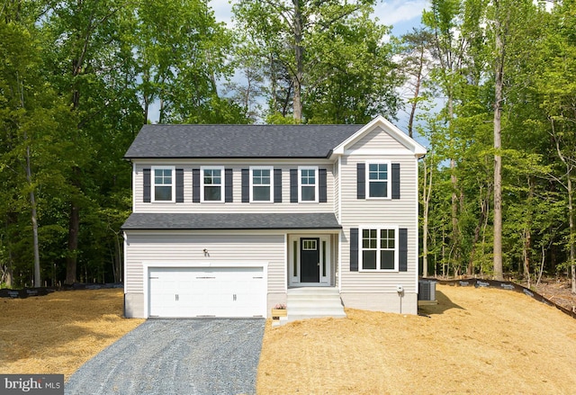 view of front of house with a garage and central AC