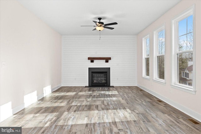 unfurnished living room featuring ceiling fan and light hardwood / wood-style flooring