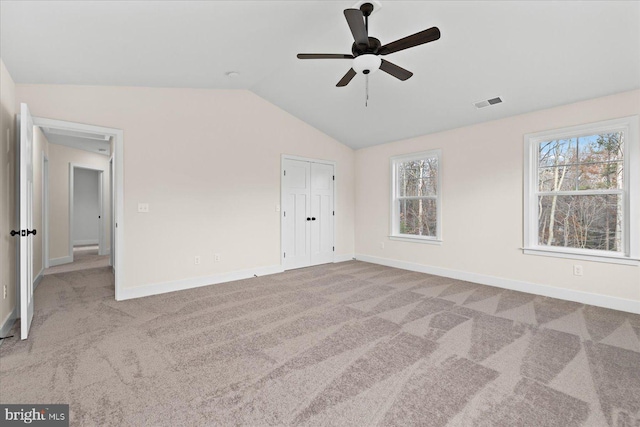 unfurnished bedroom featuring lofted ceiling, light colored carpet, and ceiling fan