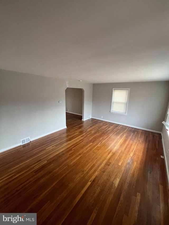 unfurnished room with dark hardwood / wood-style flooring