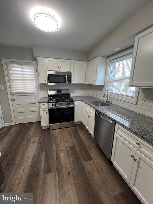 kitchen featuring dark hardwood / wood-style flooring, sink, stainless steel appliances, and white cabinets