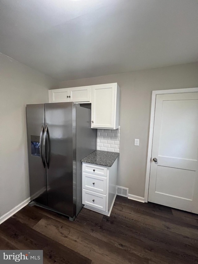 kitchen featuring backsplash, stainless steel refrigerator with ice dispenser, light stone countertops, white cabinets, and dark hardwood / wood-style flooring