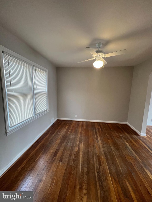 spare room with dark hardwood / wood-style floors and ceiling fan