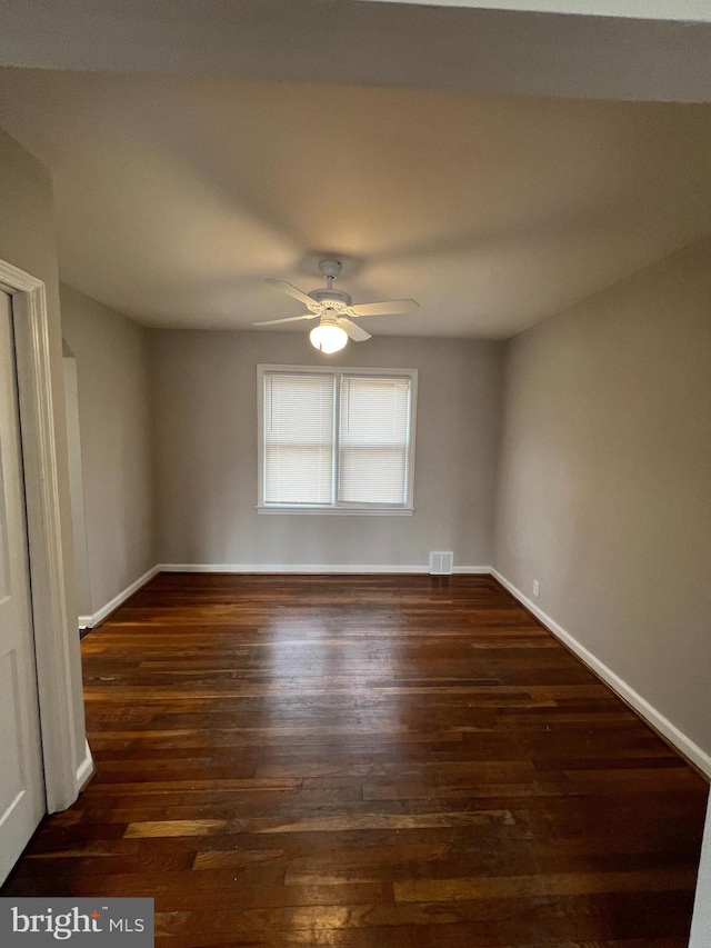 spare room with ceiling fan and dark hardwood / wood-style flooring