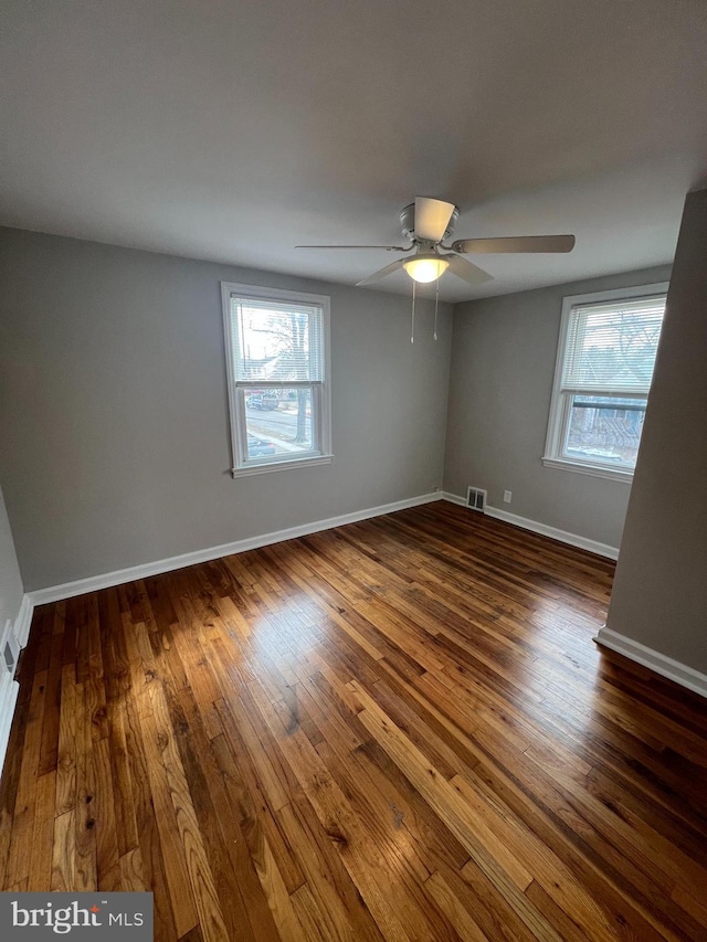 unfurnished room with dark hardwood / wood-style floors and ceiling fan