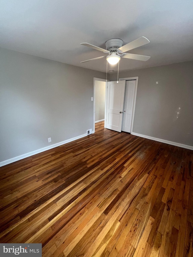 unfurnished bedroom with ceiling fan, wood-type flooring, and a closet