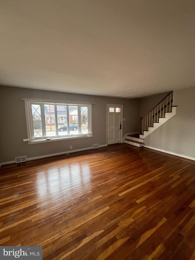 unfurnished living room with dark hardwood / wood-style flooring