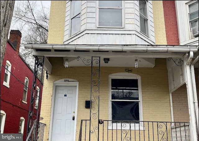 view of exterior entry featuring covered porch