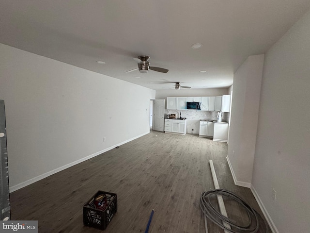 unfurnished living room with wood-type flooring and ceiling fan