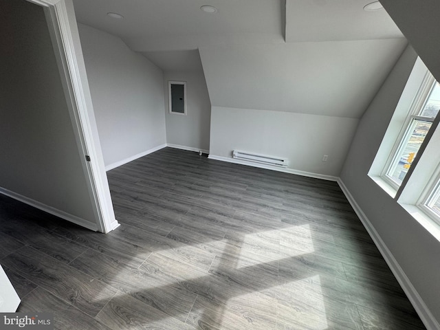 bonus room with dark hardwood / wood-style flooring, lofted ceiling, electric panel, and baseboard heating