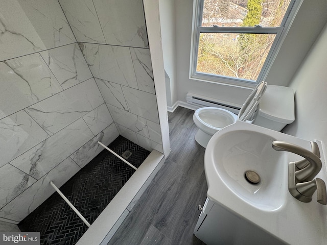 bathroom featuring sink, hardwood / wood-style flooring, toilet, and tiled shower