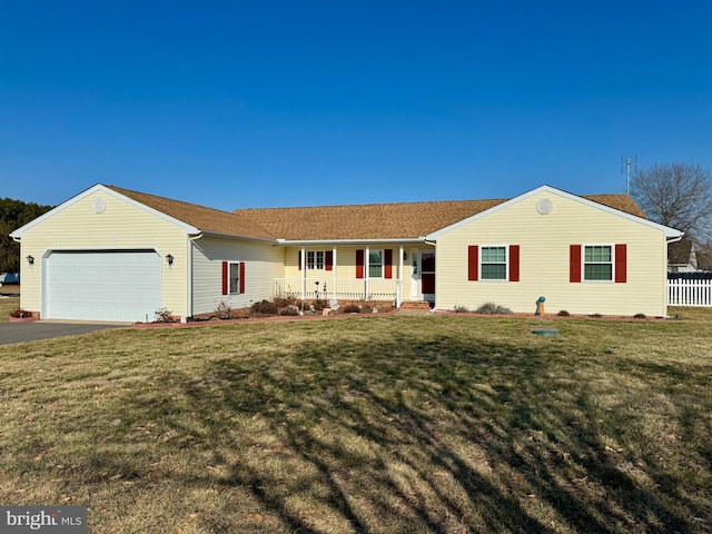 ranch-style home featuring covered porch, a front yard, and a garage