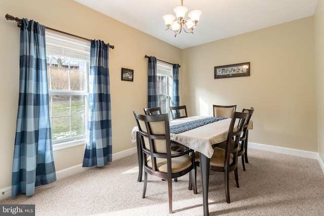 dining space featuring carpet and a notable chandelier