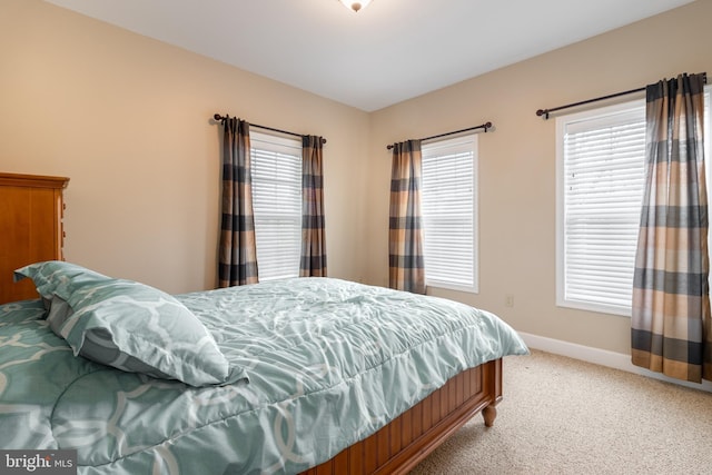 bedroom with multiple windows and carpet