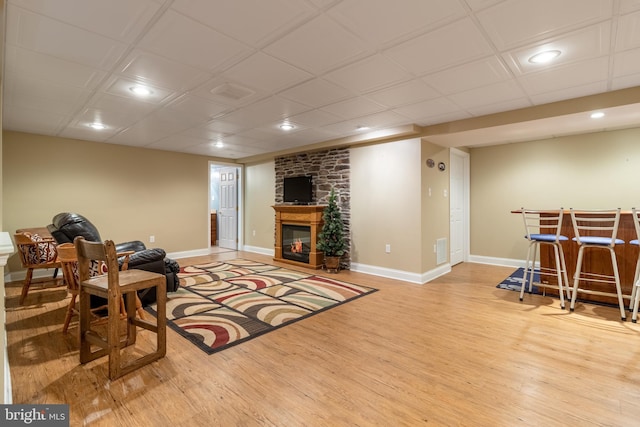 living room featuring bar, a fireplace, and light hardwood / wood-style flooring