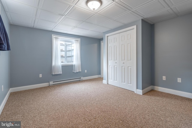 unfurnished bedroom featuring a baseboard radiator, carpet, and a closet