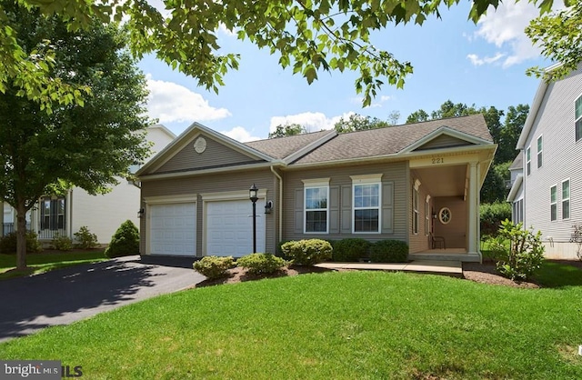 ranch-style home featuring a garage and a front lawn