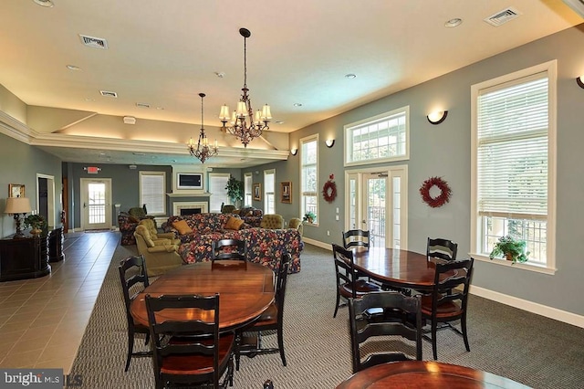 tiled dining area with plenty of natural light, a chandelier, and french doors