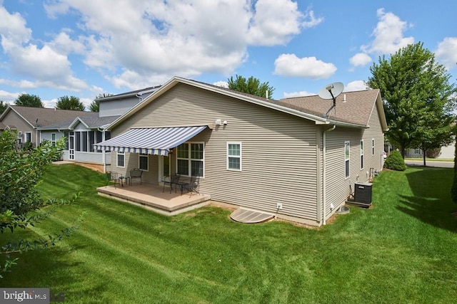 rear view of property with a patio, central AC unit, and a lawn