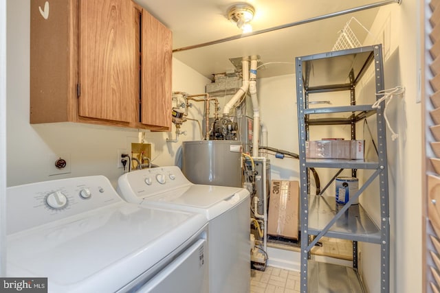 washroom featuring cabinets, washing machine and dryer, and water heater