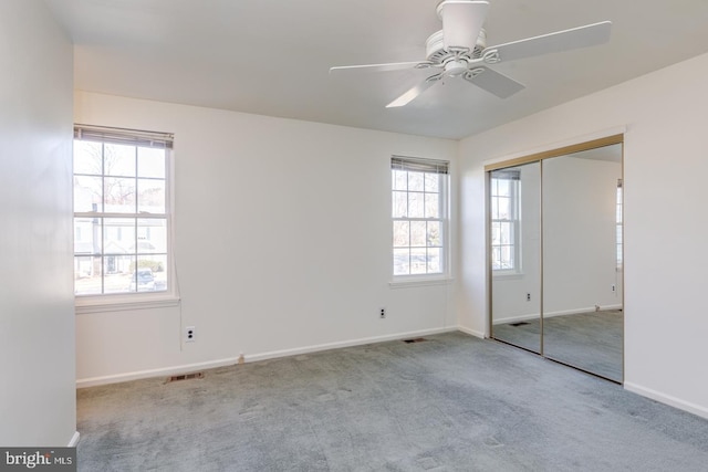 unfurnished bedroom featuring light carpet, ceiling fan, and a closet