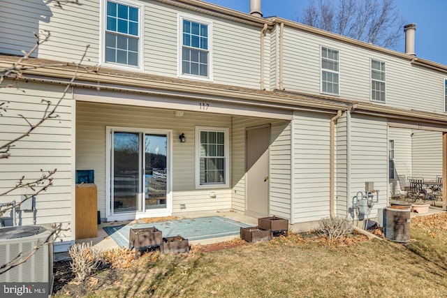 rear view of house featuring a yard and central AC unit