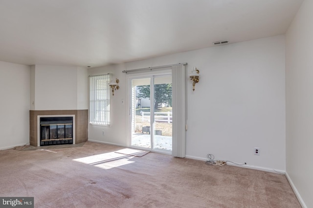 unfurnished living room featuring a fireplace and light colored carpet