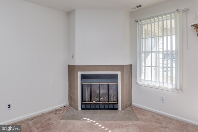 room details featuring a tiled fireplace and carpet