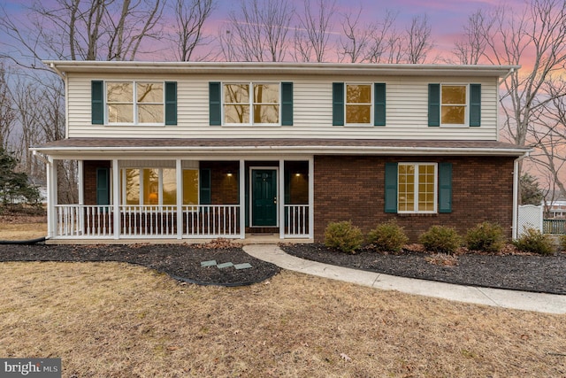 front of property with a porch and a lawn