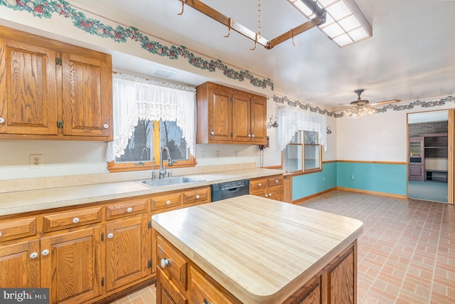 kitchen with ceiling fan, dishwasher, sink, and a kitchen island