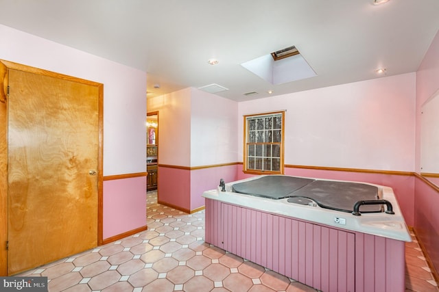 misc room featuring a jacuzzi and a skylight