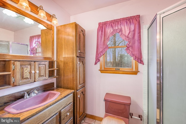 bathroom featuring tile patterned flooring, toilet, vanity, and a shower with shower door