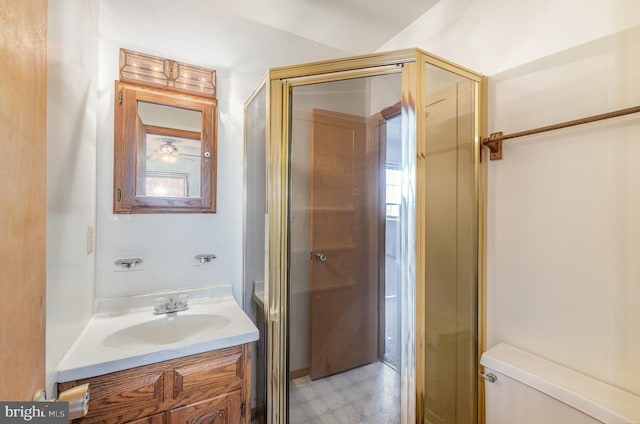 bathroom featuring vanity, toilet, and an enclosed shower