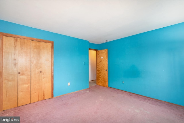 unfurnished bedroom featuring a closet and carpet flooring