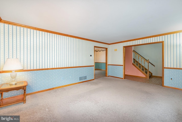 empty room with crown molding and carpet