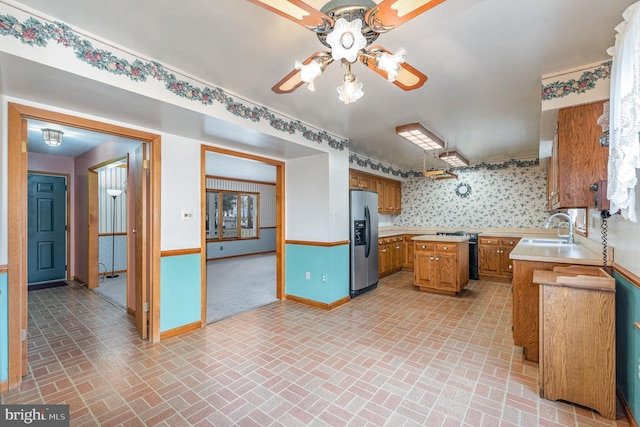 kitchen featuring sink, ceiling fan, and stainless steel refrigerator with ice dispenser