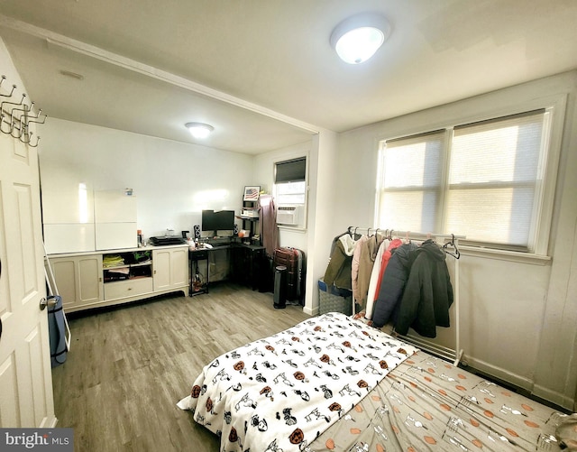 bedroom with cooling unit and light hardwood / wood-style floors